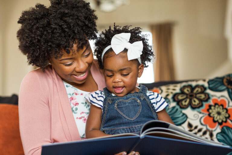 Mother reading a book to her little girl.